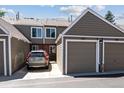 Exterior view of townhome with attached garage, driveway and lush landscaping at 7474 E Arkansas Ave # 17-07, Denver, CO 80231