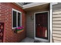 A charming brick-accented front entrance with a decorative security door and flower box at 7474 E Arkansas Ave # 17-07, Denver, CO 80231