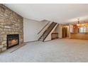 Spacious living room with a stone fireplace and staircase at 7474 E Arkansas Ave # 17-07, Denver, CO 80231