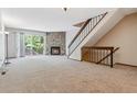 Spacious living room with stone fireplace, plush carpeting, and access to outdoor area at 7474 E Arkansas Ave # 17-07, Denver, CO 80231