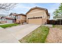 Inviting home exterior showcasing a two-car garage, stone accents, and landscaped front yard at 9844 Norfolk St, Commerce City, CO 80022