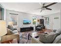 Bright living room features plush seating, large windows, ceiling fan and modern decor at 742 Mockingbird Ln, Brighton, CO 80601
