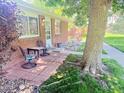Brick home featuring a cozy outdoor seating area on the front porch, shaded by a mature tree at 9255 E Lehigh # 213, Denver, CO 80237