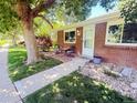 Inviting brick home with outdoor seating area on the front porch and a well-maintained lawn at 9255 E Lehigh # 213, Denver, CO 80237
