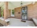 Inviting front porch featuring stylish tile flooring, decorative door, and brick pillars at 2738 W 38Th Ave, Denver, CO 80211