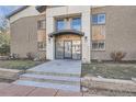 Close up shot of the entrance to the building with double doors and concrete stairs at 2460 W Caithness Pl # 104, Denver, CO 80211