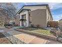 Two-story brick building featuring a covered entrance, landscaping, and a well-maintained facade at 2460 W Caithness Pl # 104, Denver, CO 80211