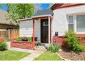 Charming home's front entry features a dark wood door, brick accents, and a welcoming Hello doormat at 3024 S Sherman St, Englewood, CO 80113