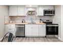 Well-lit kitchen featuring stainless steel appliances, light wood countertops, and tiled backsplash at 3024 S Sherman St, Englewood, CO 80113