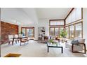 Spacious living room featuring large windows, exposed brick accent wall, and modern furniture at 4998 W 101St Ave, Westminster, CO 80031