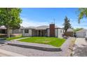 A single-story home featuring a brick chimney, covered porch, and a well-maintained lawn and detached garage at 5369 S Sherman St, Littleton, CO 80121