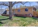 Quaint brick home with green lawn and mature shade tree in a quiet residential neighborhood at 6280 Quay St, Arvada, CO 80003