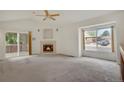 Sunlit living room with a fireplace, large windows, and sliding doors to the deck at 1972 S Carr St, Lakewood, CO 80227