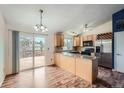 Bright kitchen with wood cabinets, granite countertops, stainless steel appliances, and access to deck at 18981 E Mercer Dr, Aurora, CO 80013
