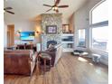 Inviting living room featuring a stone fireplace, large windows, and comfortable seating at 620 Coyote Trl, Elizabeth, CO 80107