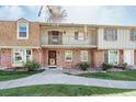 Inviting brick townhome with a charming balcony, complemented by a well-kept lawn and walkway at 2523 E Geddes Ave, Centennial, CO 80122
