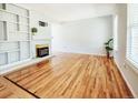 Spacious living room featuring hardwood floors, a cozy fireplace, and built-in bookshelves for display at 2523 E Geddes Ave, Centennial, CO 80122