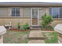 Home's entry features a decorative glass door and a small garden at 5481 Xanadu St, Denver, CO 80239