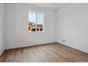 Bright, light-filled bedroom features wood-look floors and view of new construction at 45909 Wood Thrush Ave, Bennett, CO 80102