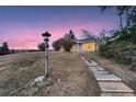 Inviting exterior view of home with stone pathway and well-maintained lawn at dusk at 34 S Raleigh St, Denver, CO 80219