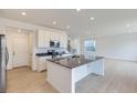 Modern kitchen with white cabinets, stainless steel appliances, and an island with a sink at 28625 E 6Th Pl, Watkins, CO 80137