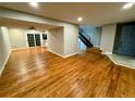 Open-concept living room with beautiful wood floors and sliding glass doors to the backyard at 528 S Youngfield Ct, Denver, CO 80228