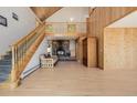 Spacious living room featuring a stone fireplace, vaulted ceilings, and a wooden staircase at 3581 Gap Rd, Golden, CO 80403