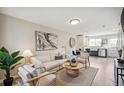 Open living room featuring a light beige sofa and wooden coffee table at 4336 Decatur St, Denver, CO 80211