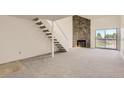 Spacious living room featuring plush carpeting, stone fireplace and sliding glass doors at 3558 S Depew St # 302, Denver, CO 80235