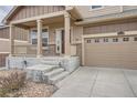 Inviting porch with stylish columns, a cozy entrance, and a view of the front yard and two-car garage at 24288 E Brandt Ave, Aurora, CO 80016