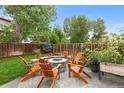 Backyard patio features a stone fire pit and wooden Adirondack chairs at 5494 S Ireland St, Centennial, CO 80015
