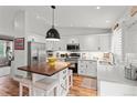 Bright kitchen with white cabinets, stainless steel appliances, and wood flooring at 5494 S Ireland St, Centennial, CO 80015