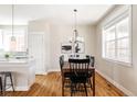 Bright dining room featuring hardwood floors and a modern chandelier with a large window at 2879 Shadow Lake Rd, Lafayette, CO 80026