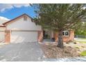 Traditional home with brick accents, a well-maintained lawn, and mature landscaping at 16753 W 61St Ln, Golden, CO 80403