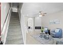 Spacious living room with stairway, open floor plan, fireplace, and ceiling fan at 10693 W 63Rd Dr # 106, Arvada, CO 80004