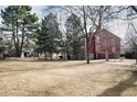 Exterior of a red condo building on a grassy lawn with mature trees and pathways at 2686 E Otero Pl # 12, Centennial, CO 80122