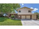 Charming two-story home with brick accents and a two-car garage, surrounded by mature trees and lush greenery at 11410 W 72Nd Pl, Arvada, CO 80005