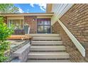 Inviting front porch with wood stairs and brick accents, leading to the front door with a decorative screen at 11410 W 72Nd Pl, Arvada, CO 80005