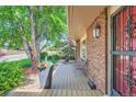 Cozy front porch with chairs, planter and brick exterior under covered entrance at 11410 W 72Nd Pl, Arvada, CO 80005