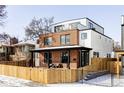 Stylish brick and white home featuring a rooftop deck, cozy front porch, and fenced yard at 1683 N Zenobia St, Denver, CO 80204