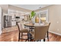 Cozy dining area with wood floors, table with chairs, and kitchen in the background at 2891 S Vaughn Way, Aurora, CO 80014