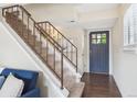 Inviting entryway featuring a carpeted staircase with metal railing and a stylish front door at 12702 Fairfax St, Thornton, CO 80241