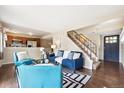 Bright living room with a staircase, open to the kitchen, featuring a modern black and white rug at 12702 Fairfax St, Thornton, CO 80241
