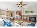 Bright, open-concept living room with hardwood floors, a fireplace, and plenty of natural light at 14247 W 84Th Cir # A, Arvada, CO 80005