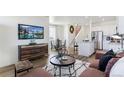 Open-concept living area with hardwood floors, modern decor, and staircase at 18724 E 99Th Ave, Commerce City, CO 80022