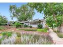 Charming home with a well-manicured front yard featuring beautiful flowers and mature trees at 4057 Bryant St, Denver, CO 80211