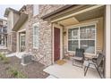 Cozy front porch with seating area, stone accents, and a welcoming entrance at 8376 Lorenzo Ln # C, Littleton, CO 80129