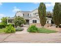 Inviting two-story home with a covered porch, blooming trees, and well-maintained landscaping at 10170 E 151St Ct, Brighton, CO 80602