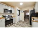 Updated kitchen with stainless steel appliances, gray cabinets, and in-unit laundry at 1161 S Perry St, Denver, CO 80219