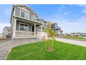 Beautiful two-story home on a green lawn with stone accents, complemented by a porch at 14239 Beebalm Ave, Parker, CO 80134